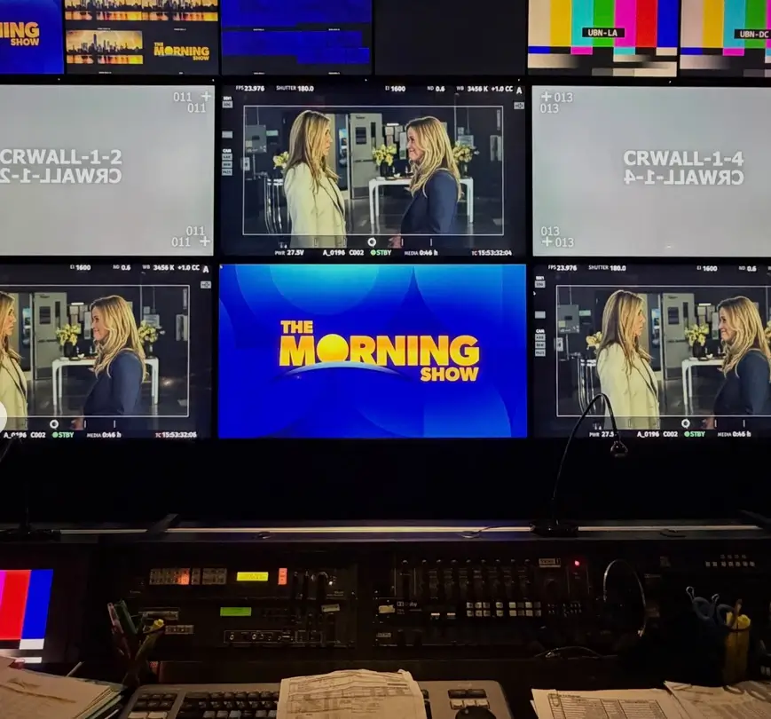 Television control room monitors displaying multiple live feeds and The Morning Show broadcast graphics during production.