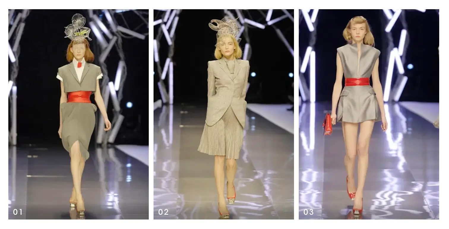 Three runway looks featuring sculptural grey tailoring with bold red waist belts and elaborate headpieces presented on a fashion catwalk.
