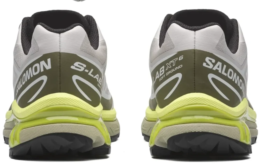 Rear view of the Salomon XT-6 trail running shoes in white, olive green, and neon yellow with large Salomon heel brand