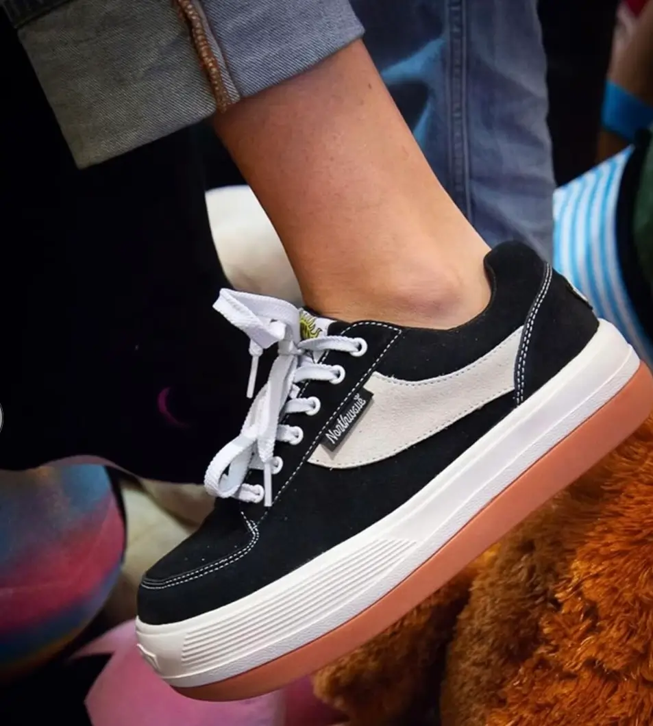 Close-up of a black Northwave shoe with white side panel, white laces, platform midsole and gum outsole worn on foot.