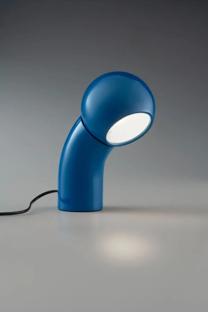 Glossy blue curve table lamp with a rounded illuminated head against a gray background