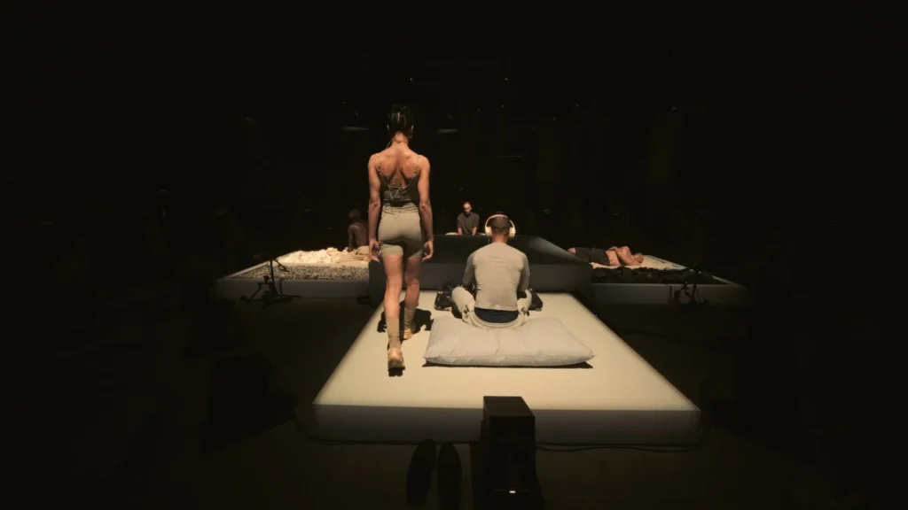 Performer Walks Across An Show Platform During An Intimate On X FKA Twigs Performance Install