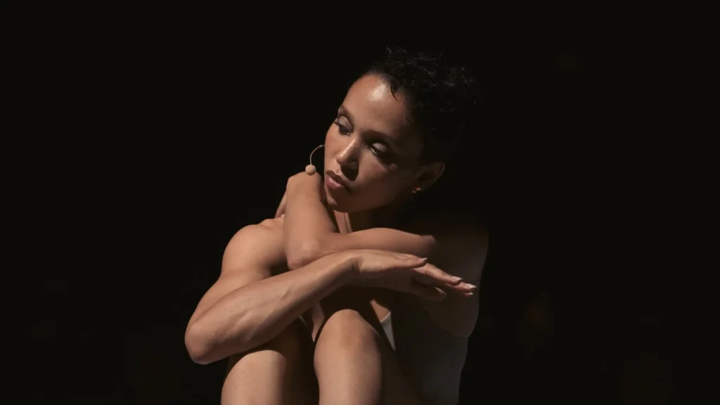 Close-Up Of FKA Twigs Wear A Headset Microphone During A Dramatically Lit Movement Performance
