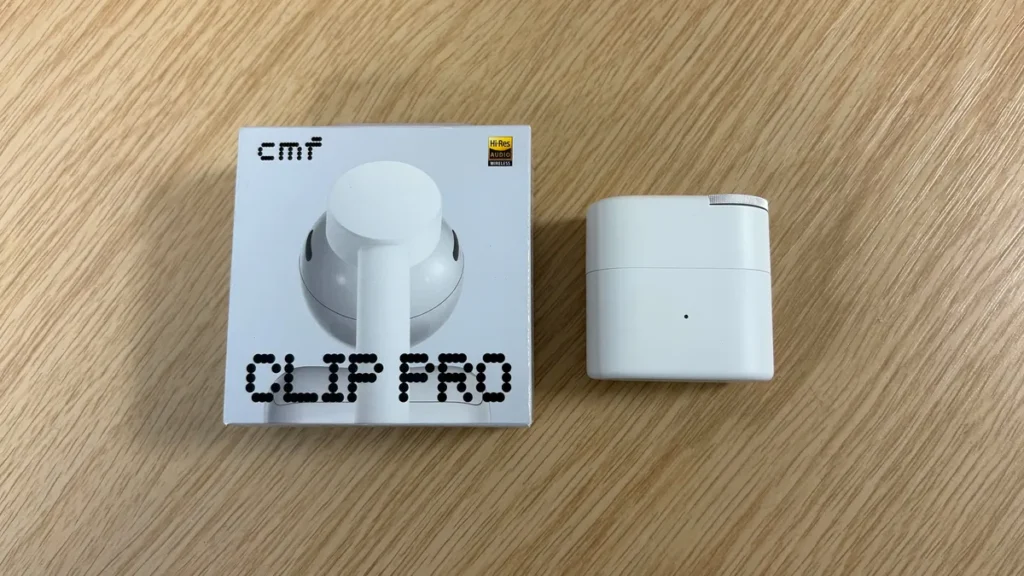 CMF Clip Pro Retail Box And White Charging Case Displayed Side By Side On A Wooden Surface