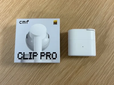 CMF Clip Pro Retail Box And White Charging Case Displayed Side By Side On A Wooden Surface