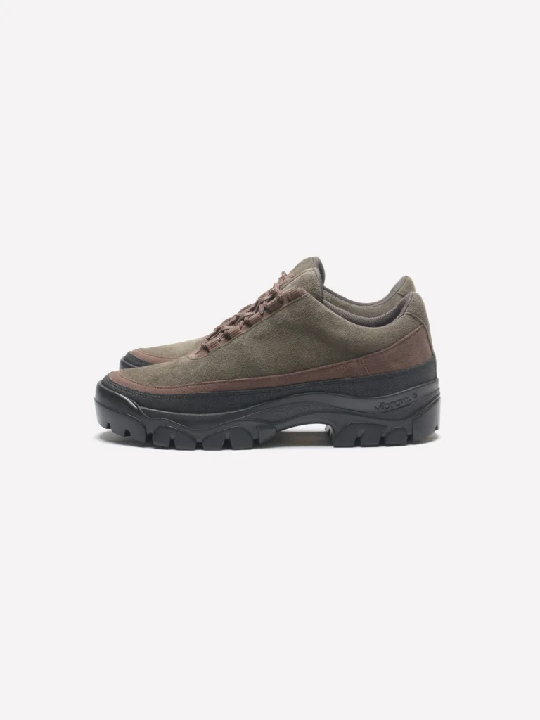 Olive green suede low-top hiking shoe with brown suede trim, tonal hiking laces, and a chunky black Vibram lug sole