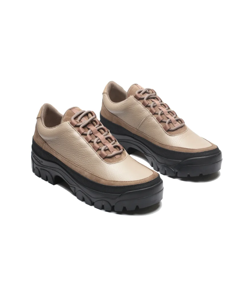 Angled view of beige leather hiking shoes with tan suede overlays, hiking laces, and thick black lugged sole