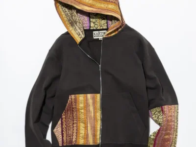 Black zip-up hoodie with multi-hue woven textile panels on the hood, pocket, and sleeve