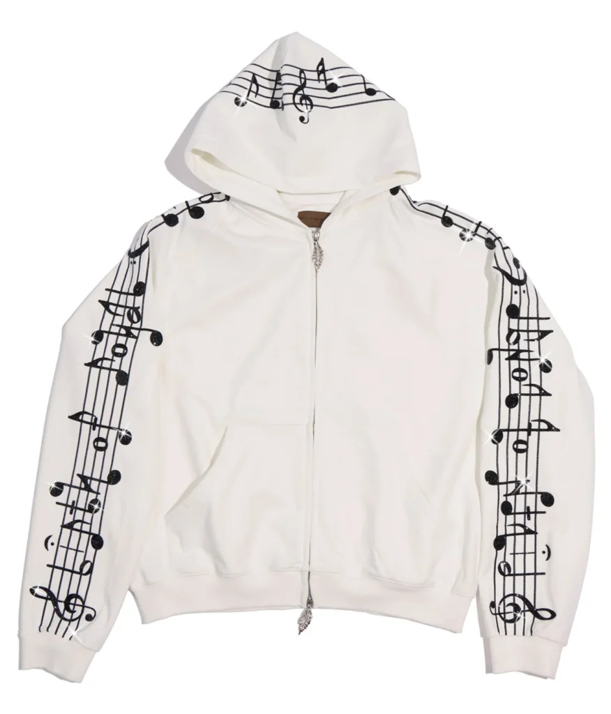White zip hoodie embroidered with black musical staff and note graphics across the hood and sleeves, featuring a full-length zipper and front pouch pocket