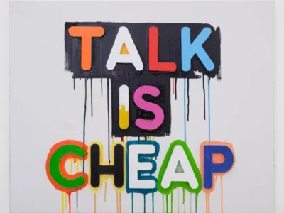 Colorful graffiti-style artwork reading "TALK IS CHEAP" with bold block letters and dripping paint on a white background