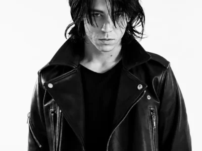 Black-and-white cover portrait of Connor Lawrence Hickey with tousled shoulder-length hair wearing a structured black leather biker jacket, staring directly into the camera beneath the editorial headline