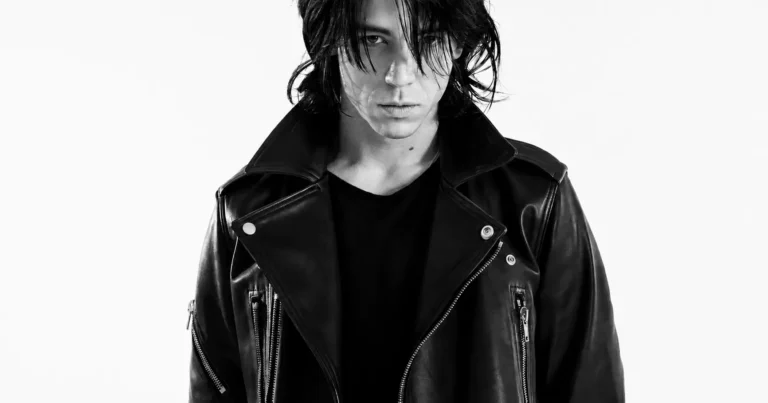 Black-and-white cover portrait of Connor Lawrence Hickey with tousled shoulder-length hair wearing a structured black leather biker jacket, staring directly into the camera beneath the editorial headline