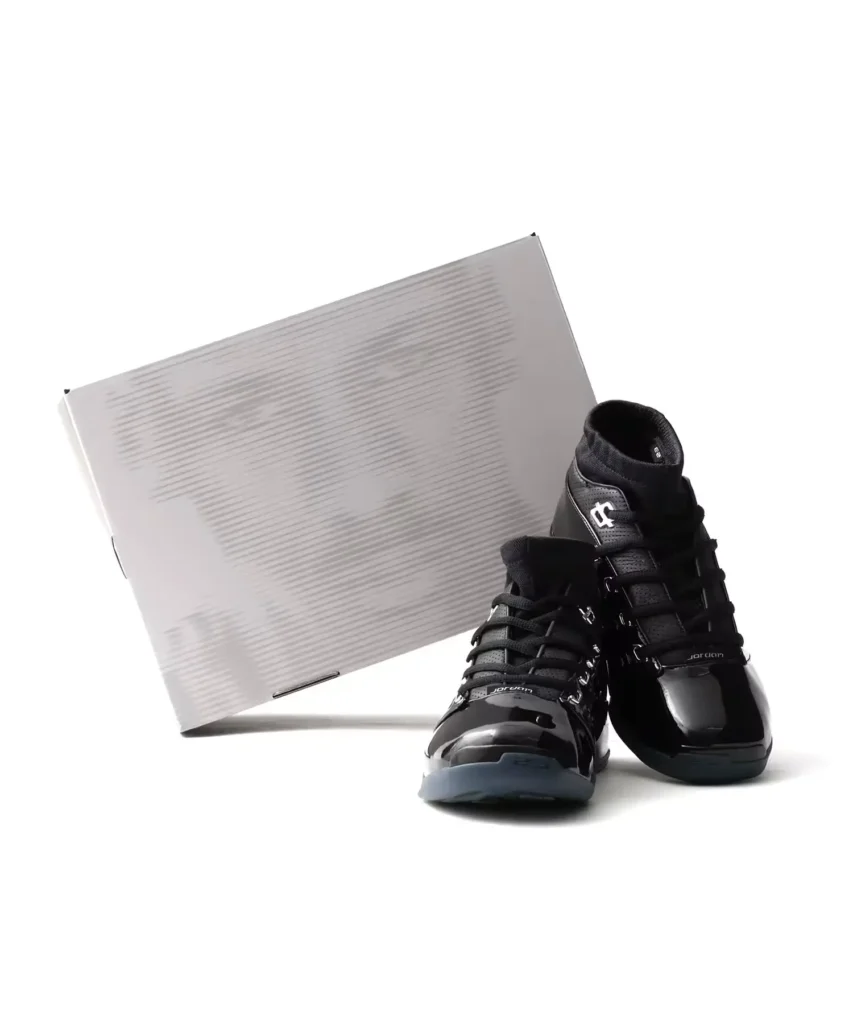 Pair of black Jordan high-tops display beside a white shoebox against a white background