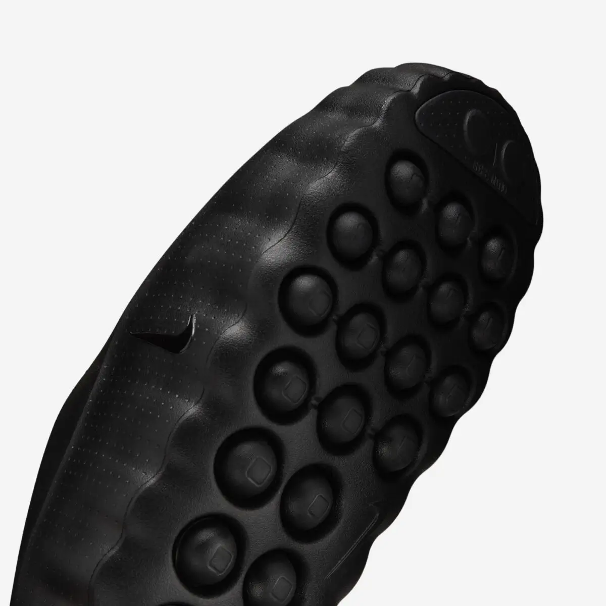 Close-up angled view of a black Nike mule highlighting the sculpted foam upper, ripple-edge sidewall, raised Swoosh branding, and circular traction pods on the outsole.