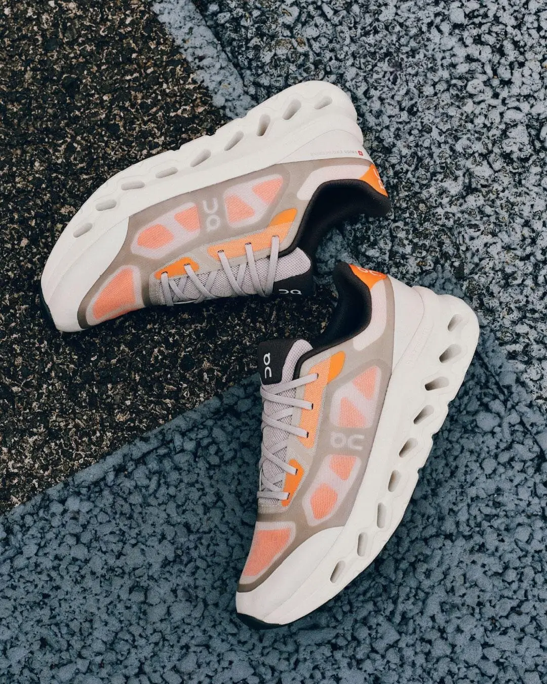 Gray And Orange On Running Shoes Arranged On Textured Pavement