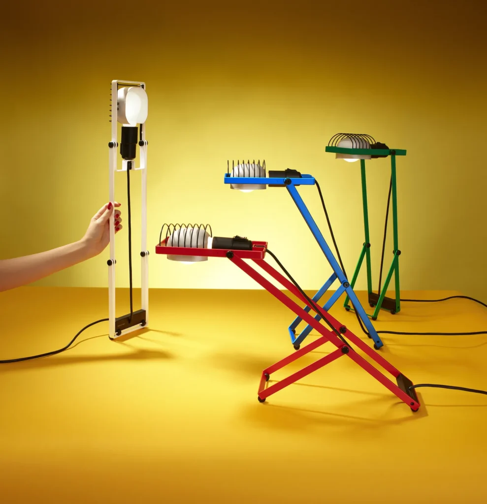 Red, blue, green, and white adjust geometric lamps display against a vivid yellow background