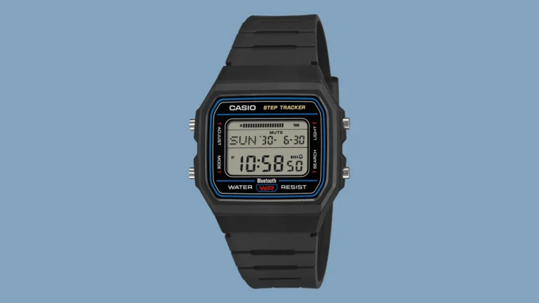 Front three-quarter view of the black Casio F-B100W Step Tracker on a solid light-blue background. The square digital face shows Sunday 30, 6-30 and 10:58:50, with CASIO STEP TRACKER, Bluetooth, and WATER WR RESIST marking around the display