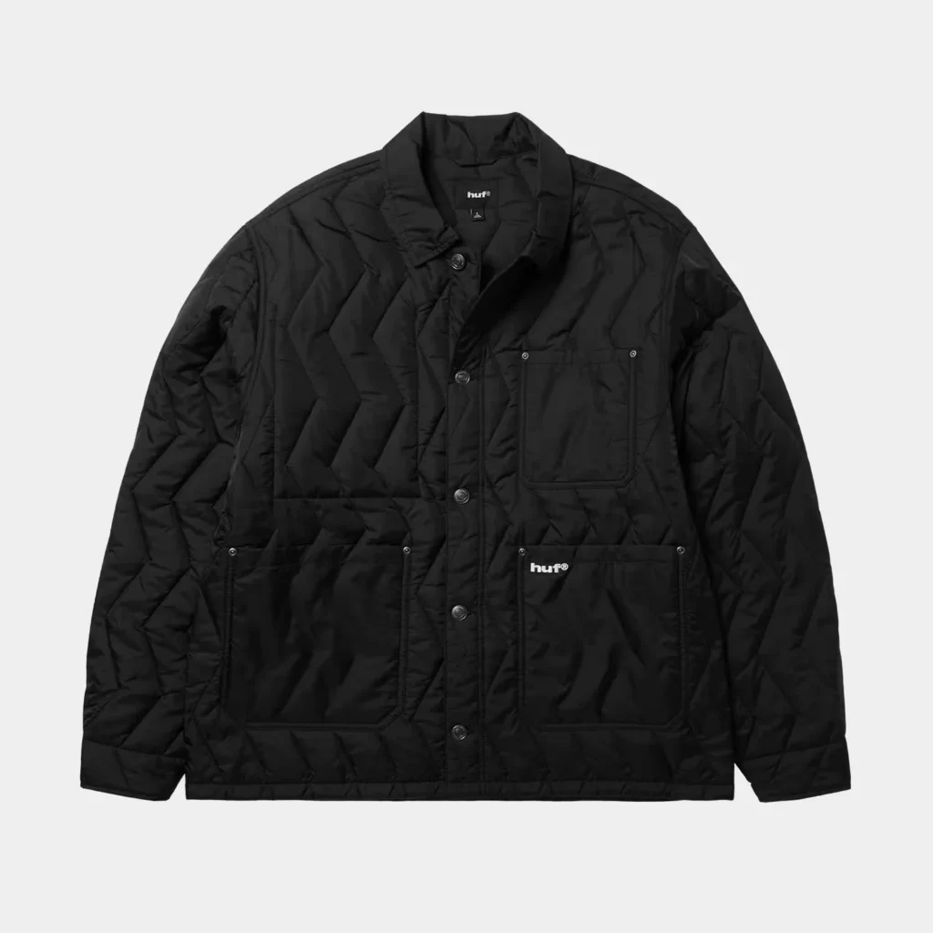 Black quilted HUF jacket with a stand collar, snap front, and four patch pockets against a light gray background