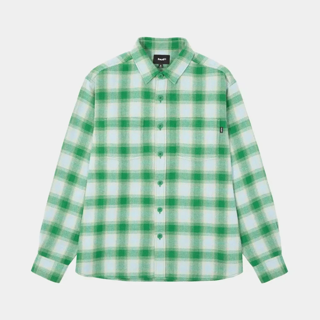 Green-and-white plaid HUF button-up shirt with long sleeves and two chest pockets, displayed against a white background