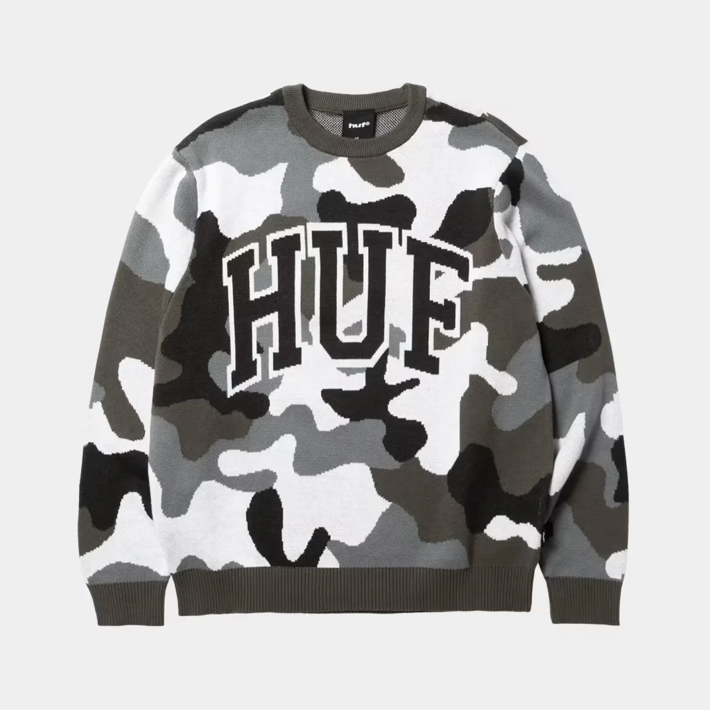 Gray, black, white, and olive camouflage HUF crewneck sweater with ribbed trim on a plain background