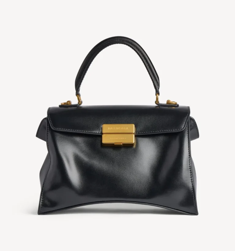 Black leather Balenciaga handbag with a curved top handle and gold clasp, centered against a white background