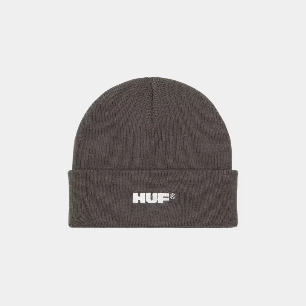 Dark gray ribbed knit beanie with a folded cuff and white HUF logo, centered against a light gray background