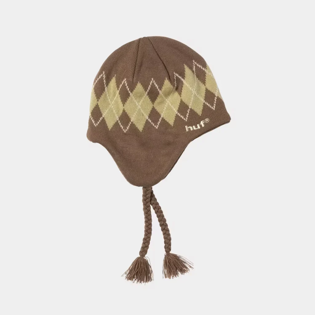 Brown knit earflap beanie with olive argyle pattern, braided ties, tassels, and white HUF logo on a plain background