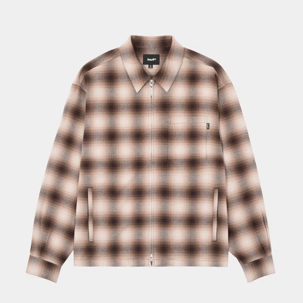 Brown-and-cream plaid zip-up jacket with a pointed collar, two front pockets and HUF label on a white background