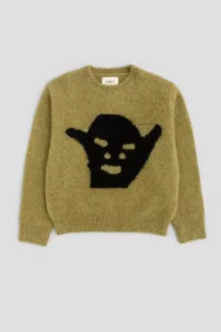 Mustard green knit sweater with a black devil face graphic, photographed against a light gray background