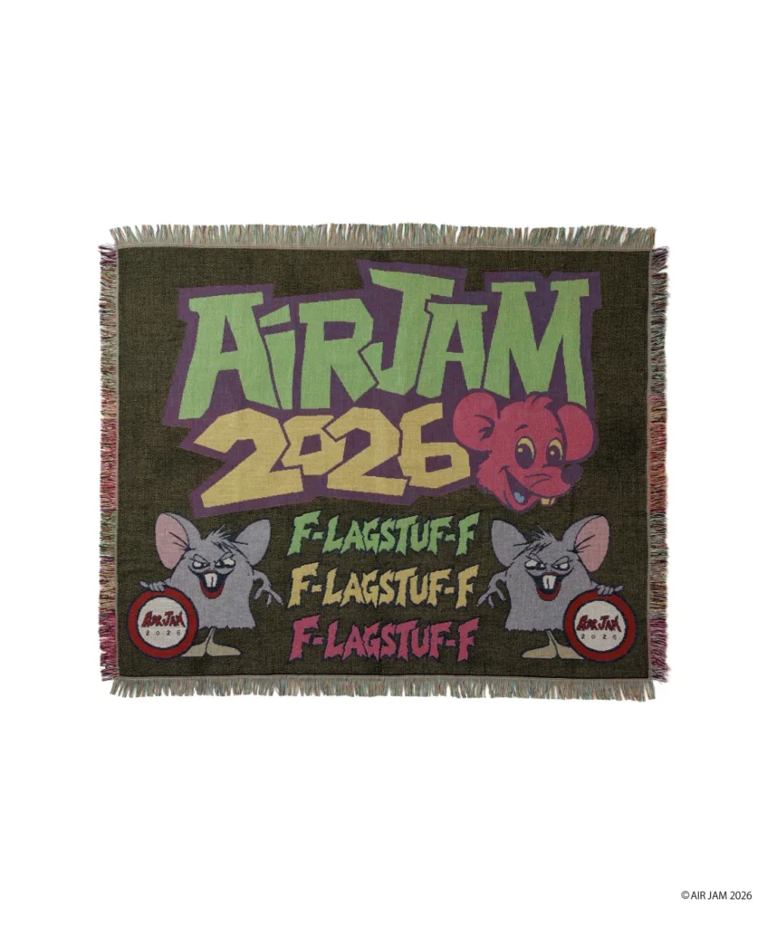 Fringed woven rug with colorful “AIR JAM 2026” lettering, cartoon mice, and repeated “FLAGSTAFF” text on a dark background