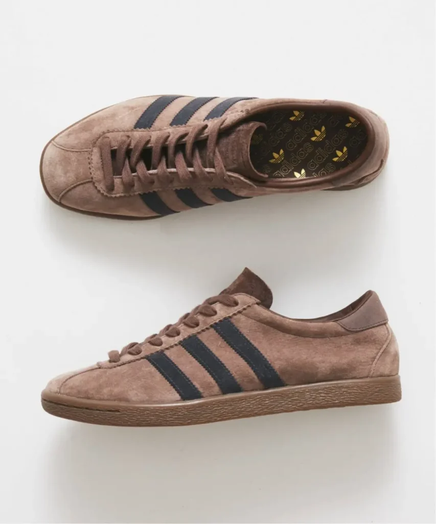 Brown suede adidas sneakers with black three-stripe branding, shown from overhead and side views on a white background