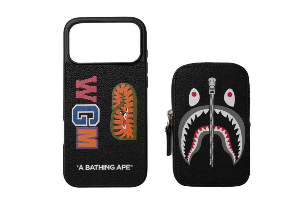 Black BAPE phone case and zip pouch with multicolored patches and shark-face graphic on a white background