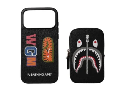 Black BAPE phone case and zip pouch with multicolored patches and shark-face graphic on a white background