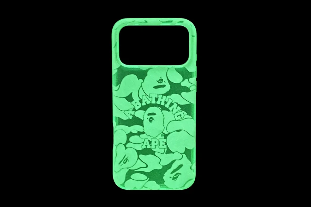 Green BAPE phone case with camouflage print and ape head graphics, centered against a black background