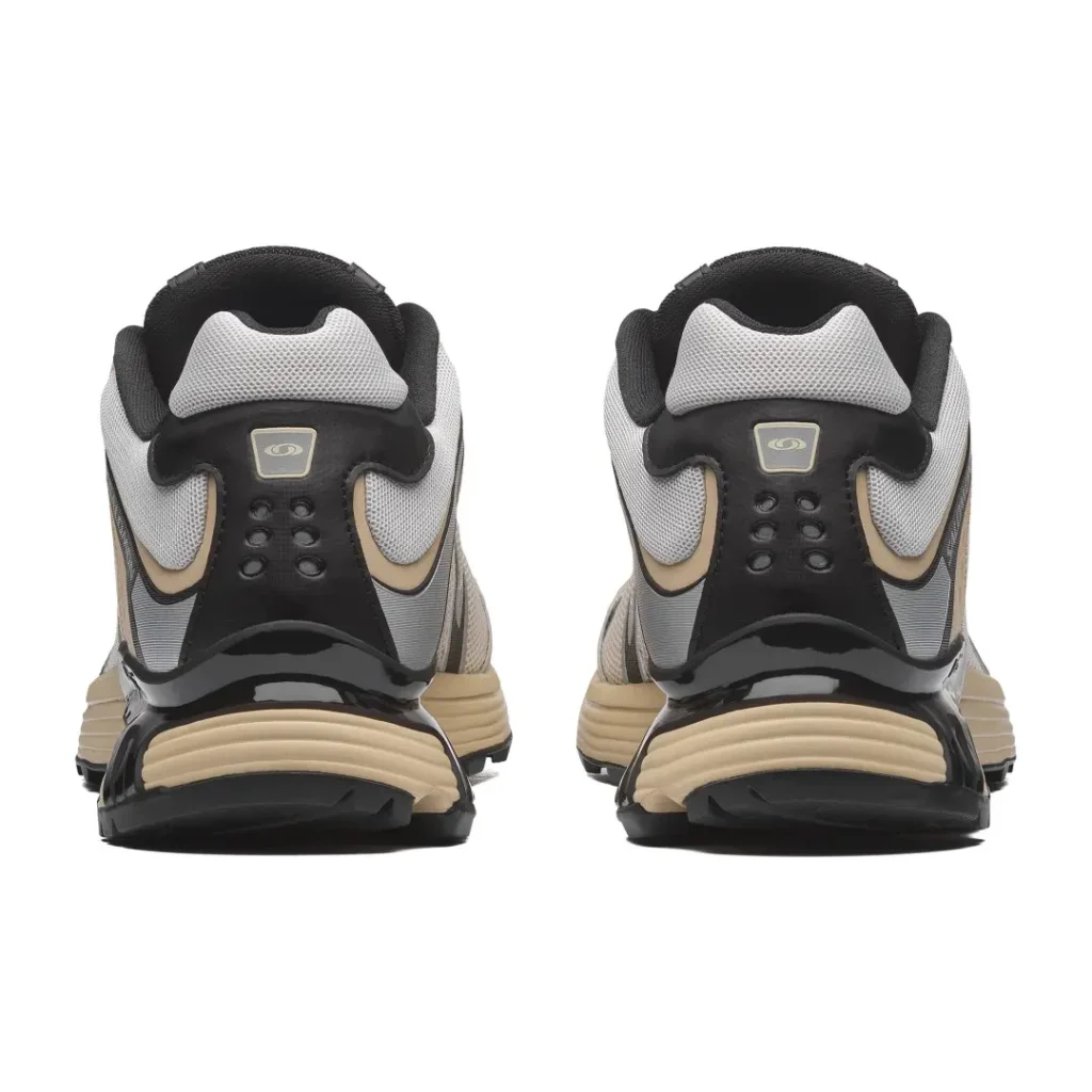 Pair of black, gray and beige sneakers shown from the back against a white background
