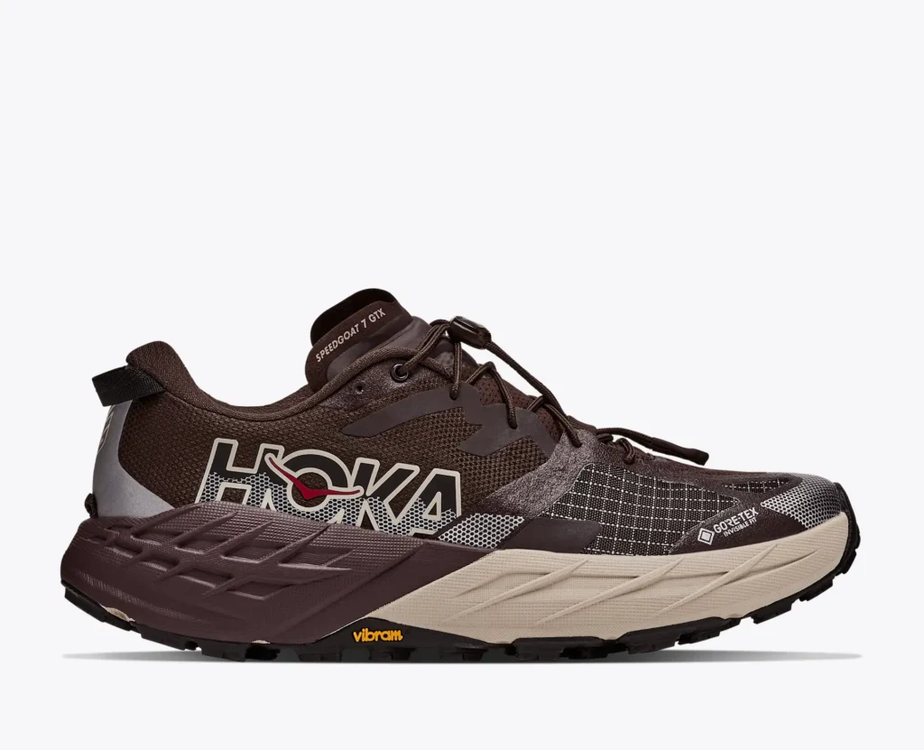 Brown HOKA Speedgoat 7 GTX trail shoe with beige midsole, black laces, Gore-Tex and Vibram details on white background