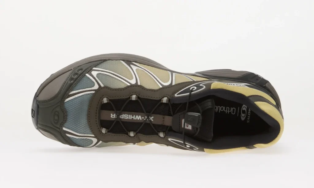 Top view of a gray, black, blue, and yellow athletic shoe with laces and mesh panels on a white background