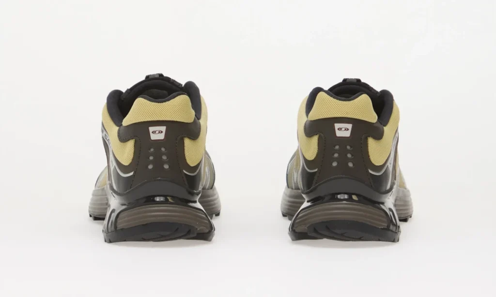 Pair of black, gray, and yellow trail shoes shown from the rear against a white background