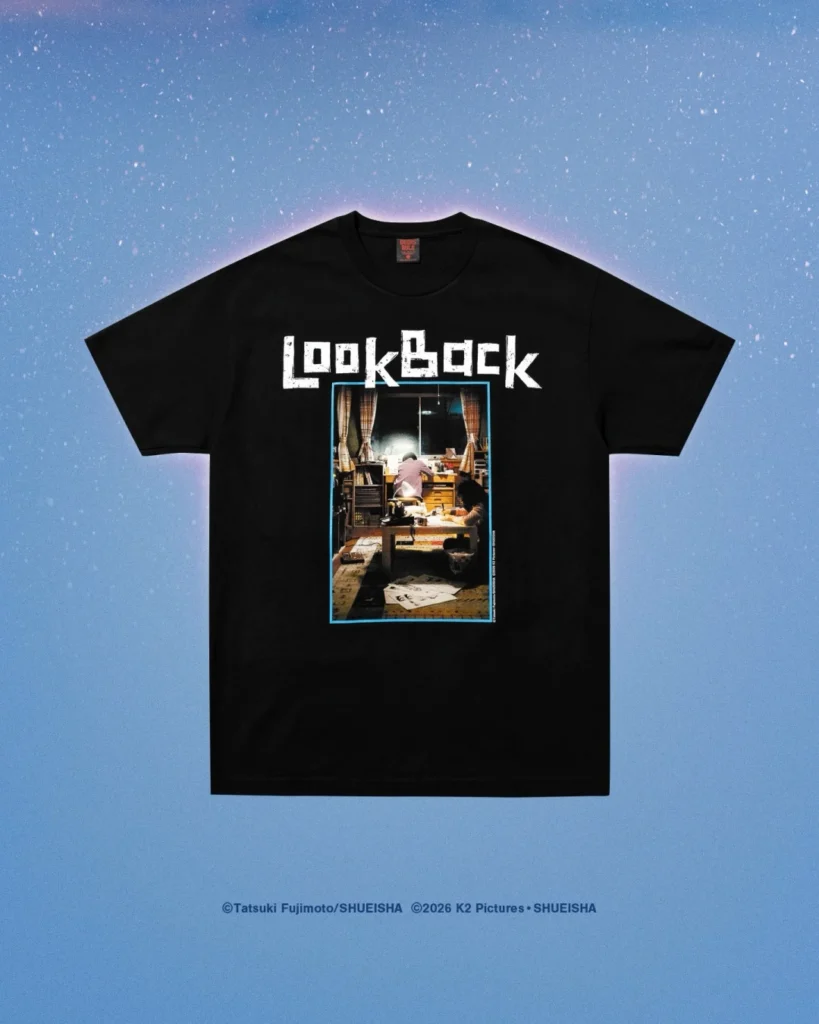 Black T-shirt with white “Look Back” lettering and a framed indoor scene graphic, displayed on a blue speckled background