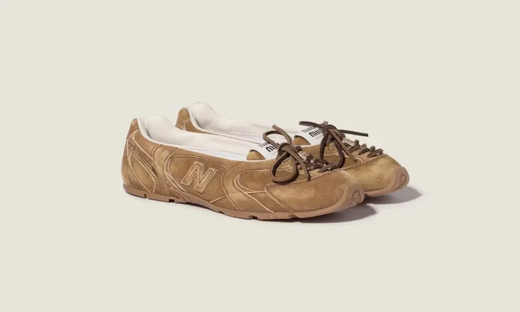 Pair of tan New Balance sneakers with brown laces on a pale background