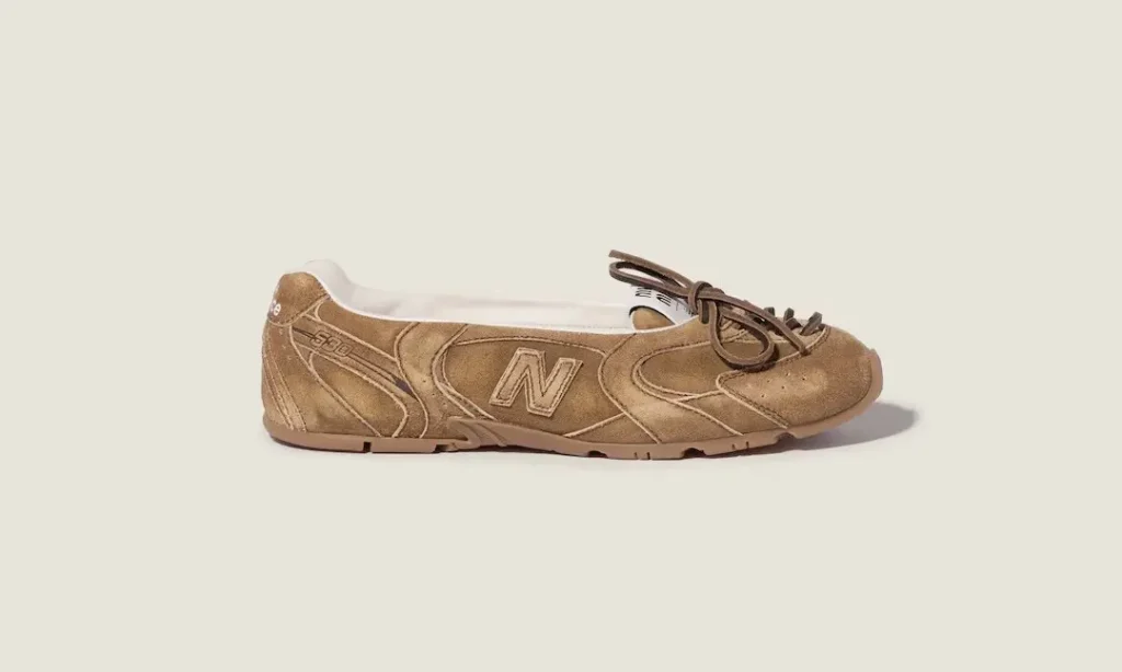 Tan New Balance 530 sneaker in side profile, with brown laces and a white interior, on a beige background