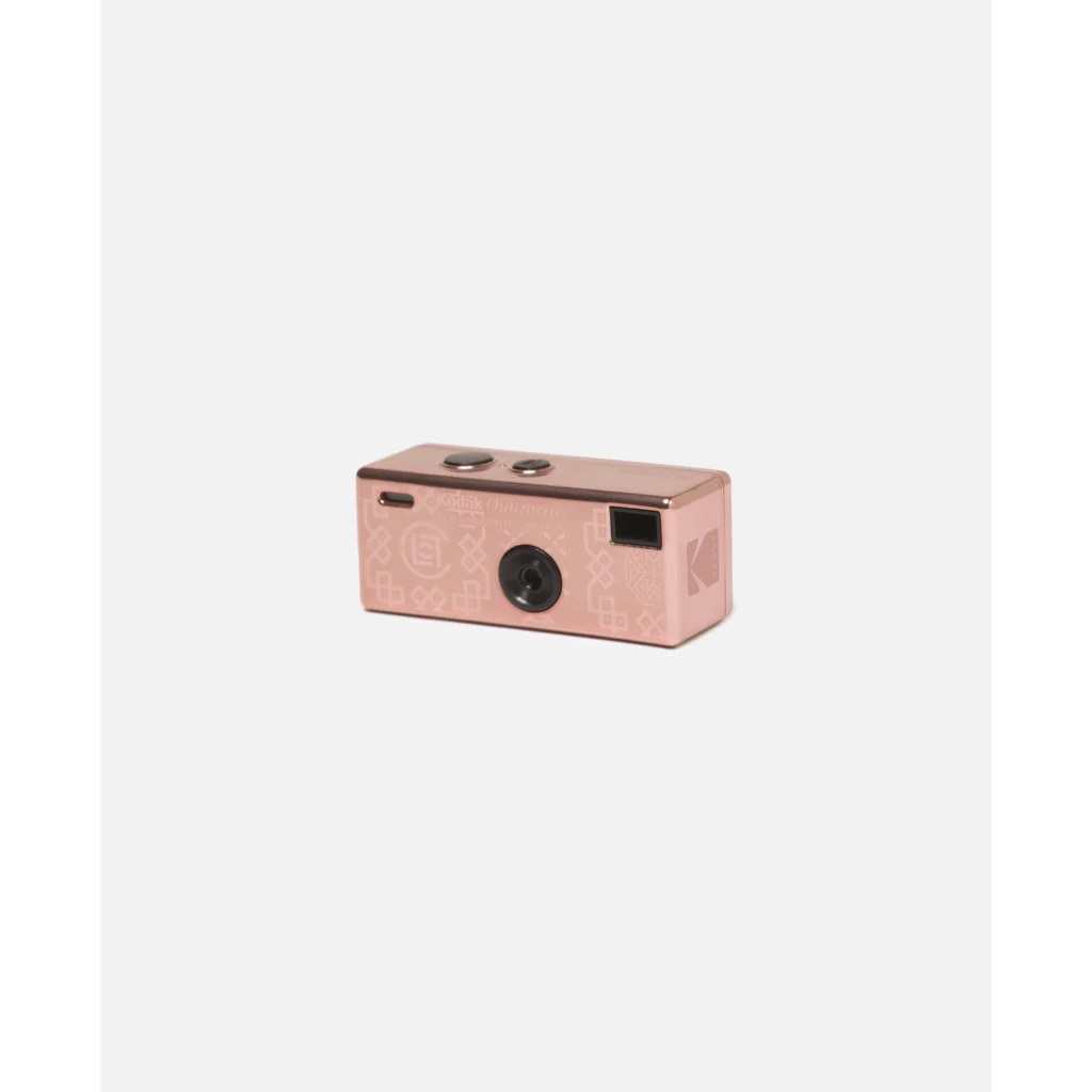 Pink Kodak Charmera compact camera with a black lens, screen, patterned graphics, and top buttons on a white background
