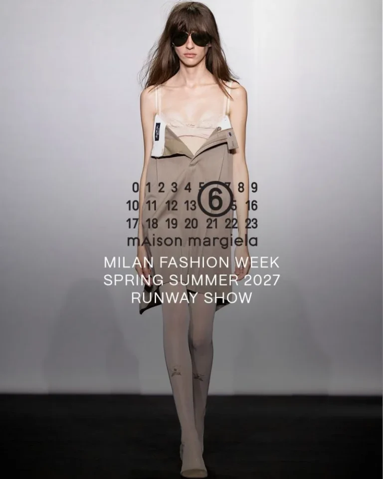 Model in dark sunglasses wears a beige camisole, asymmetrical folded skirt and sheer tights on a runway