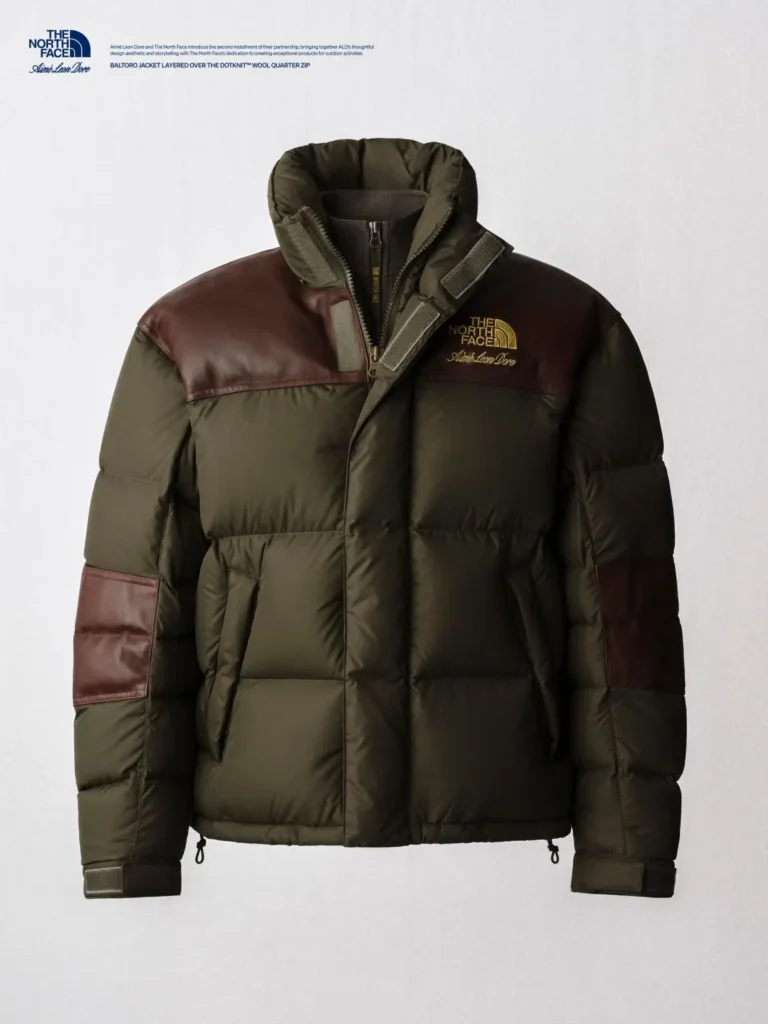 Olive green puffer jacket with brown leather shoulder and sleeve panels, high collar, and chest logo on a white background