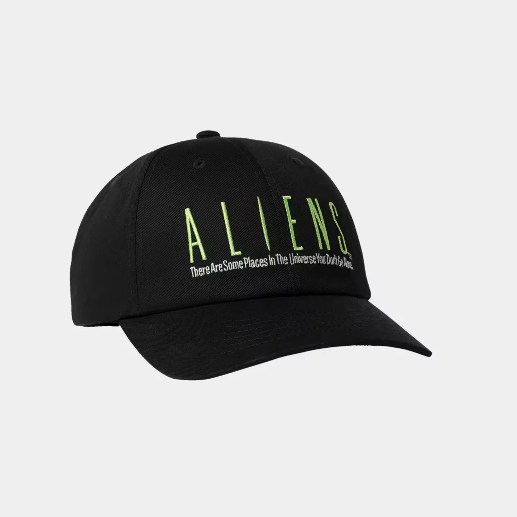 Black baseball cap with neon green “ALIENS” lettering and white slogan on the front, isolated on a light gray background