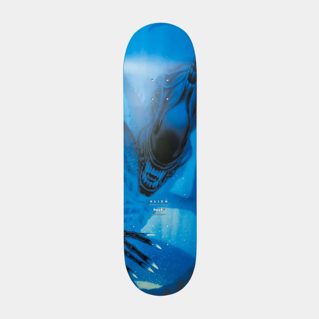 Blue skateboard deck featuring a black Xenomorph graphic, white Alien and HUF logos, and rounded ends