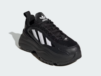 Black Adidas shoe with white three-stripe panels, chunky sole, and logo, isolated on a light gray background