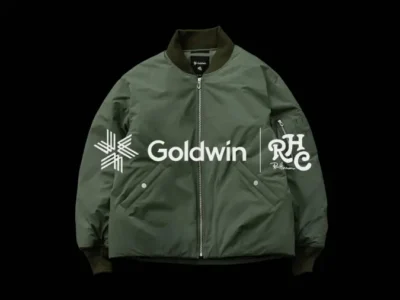 Dark green Goldwin bomber jacket with white logos, zip front, ribbed collar and cuffs, isolated on black background
