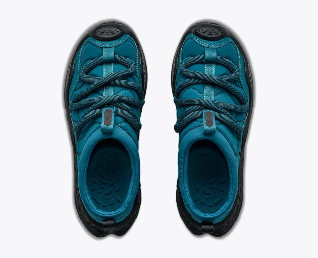 Top view of teal Hoka Ora Primo shoes with black soles, padded uppers, and crisscross cord straps on a white background