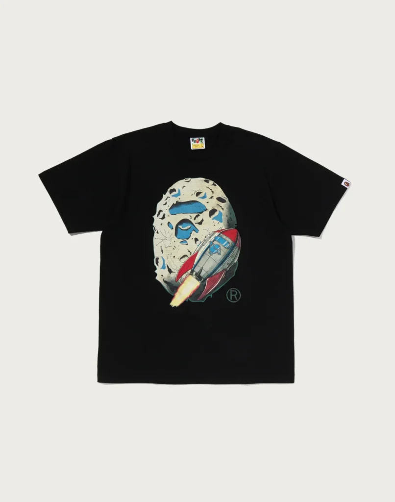 Black Tee laid flat on a pale background, with an illustrated moon and red-and-blue rocket graphic on the chest